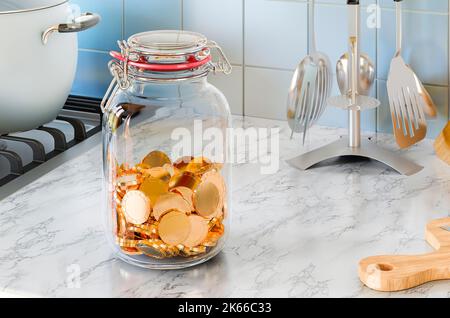Pot en verre avec pièces de monnaie dorées sur la table de cuisine. 3D rendu Banque D'Images