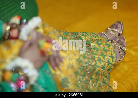 Cérémonie traditionnelle de Mayoon dans un lieu coloré à Karachi, gros plan de sandales dorées de Bride Banque D'Images