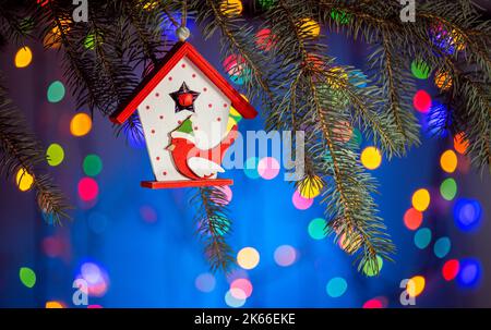 Maison de jouets de Noël avec un oiseau titmouse, fond étincelant et fabuleux avec espace de copie. Fond de Noël pour cartes postales. Décoration de Noël Banque D'Images