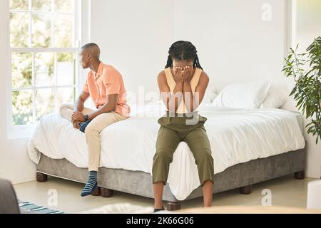 Un jeune couple afro-américain malheureux dans une chambre séparée sur un lit pendant un débat. Jeune femme noire dans son 20s couvrant son visage Banque D'Images