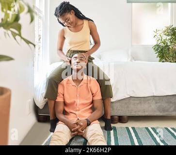 Jeune heureux insouciant et joyeux couple afro-américain se liant et appréciant se détendre ensemble à la maison. Une femme noire qui se sourit Banque D'Images