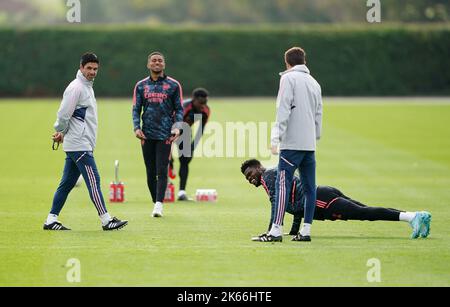 Mikel Arteta, responsable de l'arsenal (à gauche), observe Thomas Partey qui fait des poussées au cours d'une session d'entraînement au Arsenal Training Center de Londres. Date de la photo: Mercredi 12 octobre 2022. Banque D'Images