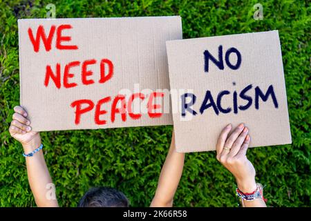 mains de jeunes portant des panneaux en carton avec des slogans contre le racisme Banque D'Images