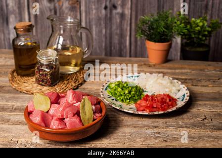 Ingrédients pour un ragoût de boeuf, morceaux de boeuf, vin blanc et légumes hachés pour le sauté. Banque D'Images