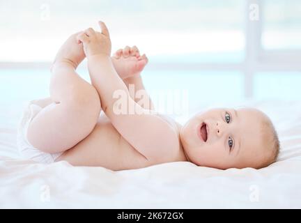 Peignez comme une momie de fille française. Un adorable petit garçon allongé sur un lit à la maison. Banque D'Images