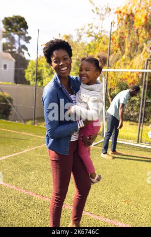 Bonne mère et fille afro-américaine passant du temps ensemble et jouant au football à l'extérieur Banque D'Images