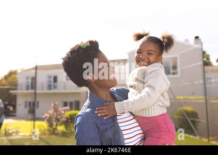 Bonne mère et fille afro-américaine passant du temps ensemble et jouant au football à l'extérieur Banque D'Images