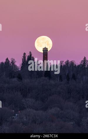 Pleine lune sur une tour au lever du soleil Banque D'Images