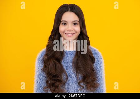 Bonne adolescente, émotions positives et souriantes de la jeune fille. Portrait d'une jeune fille adolescente souriante sur fond jaune de studio. Banque D'Images