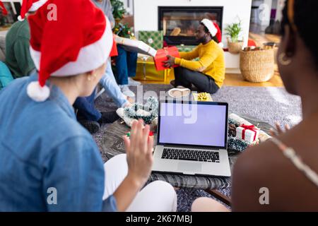 Image de divers amis célébrant noël et effectuant des appels vidéo sur ordinateur portable, espace de copie à l'écran Banque D'Images