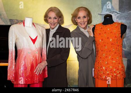 Munich, Allemagne. 12th octobre 2022. Les jumeaux Kessler, Alice (r.) et Ellen Kessler, posent avec quelques-unes des robes à l'événement de lancement pour une vente aux enchères en ligne de leurs tenues de scène au Gärtnerplatztheater. Jusqu'à 30 octobre 2022, plus de 50 ensembles de scène des jumeaux peuvent être mis aux enchères en ligne via la maison de vente aux enchères Neumeister. Le produit de la vente aux enchères sera versé aux personnes touchées par la catastrophe des inondations dans la vallée de l'Ahr. Crédit : Lennart Preiss/dpa/Alay Live News Banque D'Images