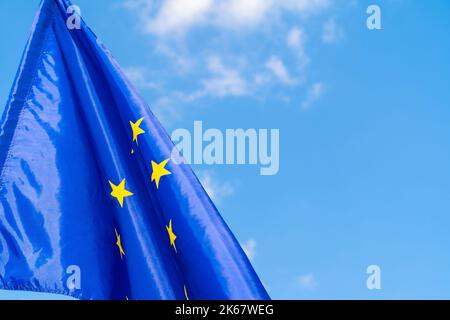 Drapeau de l'Union européenne contre le ciel bleu qui agite Banque D'Images