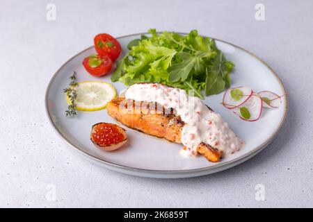 Saumon (truite) à la sauce crémeuse au champagne avec caviar rouge, arugula, tomates cerises, radis et citron. Plat français traditionnel. Mise au point sélective, clos Banque D'Images