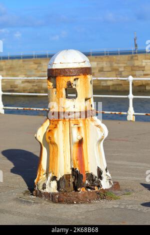 un vieux cabestan avec des taches de rouille sur le quai de whitby par une journée ensoleillée Banque D'Images