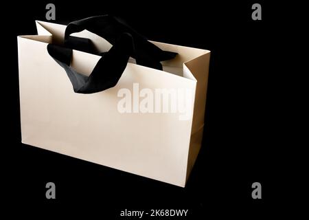 Sac en carton sur fond noir avec espace à écrire. Concept de solde du Vendredi fou. Banque D'Images