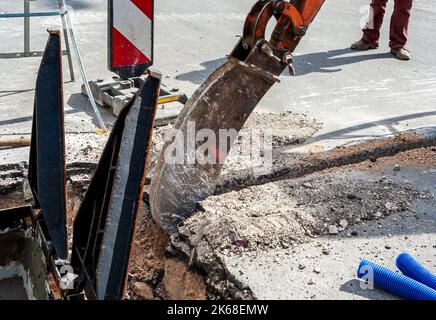 Mini pelle équipée d'un godet très étroite d'effectuer des fouilles de petite largeur dans l'exécution d'une nouvelle infrastructure de réseau fibre optique Banque D'Images