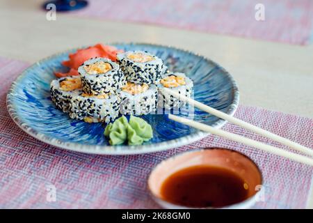 Sushi roulent avec du poisson, de l'avocat, du fromage à la crème et du sésame. Menu sushi. Cuisine japonaise. Banque D'Images