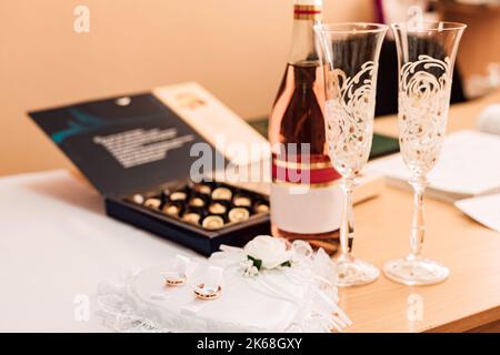 Anneaux de mariage, champagne, bonbons sur la table. Jour de mariage Banque D'Images