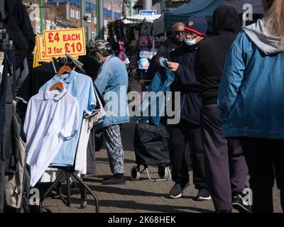 Les acheteurs de Walthamstow High Street, Londres, Royaume-Uni, avec des panneaux de livre sterling avec des prix Banque D'Images