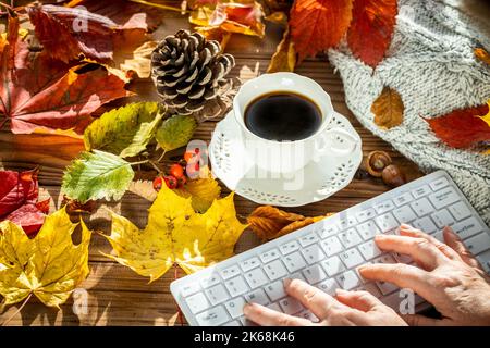 Clavier blanc pour ordinateur, feuilles d'automne colorées, tasse à café, pull chaud, concept, Style de vie, travail, détente Banque D'Images