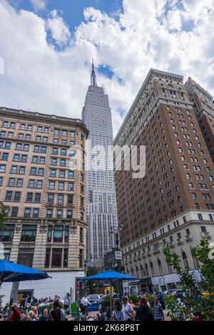 Belle vue sur 34th rue à Manhattan à New York surplombant l'Empire State Building entre deux bâtiments. Banque D'Images