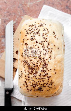 Pain de blé fait maison aux graines de lin sur une table de cuisine. Flat lay, vue de dessus Banque D'Images