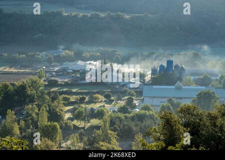 Ferme et usine dans une vallée, vapeur dans l'air froid du matin, Pyrénées, Espagne Banque D'Images