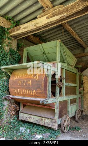 machine de fauchage vintage ombragée sous la voûte d'un bâtiment Banque D'Images