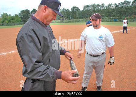 Les juges-arbitres softball pour ASA aux Etats-Unis au cours des jeux et dans preganme contrôle de chauves-souris et de compositions et des règles et le Banque D'Images