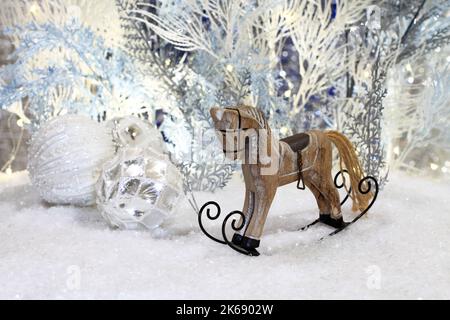 Les jouets de Noël se trouvent sur la neige artificielle sur fond d'arbres artificiels bleus et blancs. Gros plan. Prise de vue en studio de nuit. Banque D'Images