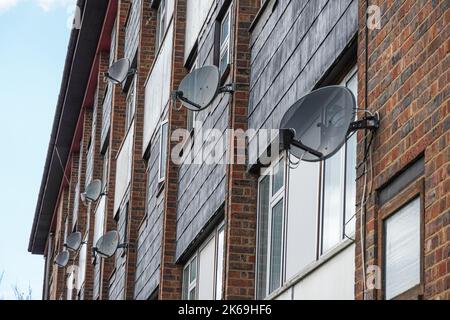 Plats satellites sur un mur de bloc résidentiel, Londres, Angleterre Royaume-Uni Banque D'Images