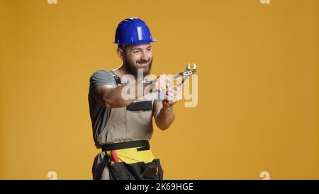 Artisan de la construction travaillant avec une clé en acier sur un projet de rénovation, utilisant une clé en acier inoxydable à extrémité ouverte sur la construction et la réparation. Un entrepreneur qui tourne le collier pour effectuer des travaux de rénovation. Banque D'Images