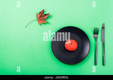Table d'Halloween avec plaque noire, citrouille décorative et feuille d'automne sur table verte. Vue de dessus, plan d'appartement. Banque D'Images
