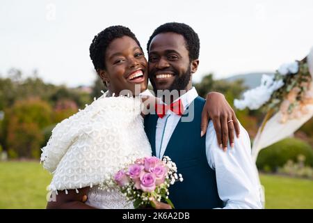 Portrait d'un heureux couple afro-américain tenant la main pendant le mariage Banque D'Images