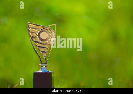 Trophée d'or isolé sur fond vert nature bokeh Banque D'Images