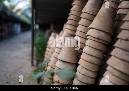 Gros plan des piles de pots de fleurs de terre cuite anciens et altérés dans le hangar de jardinage Banque D'Images