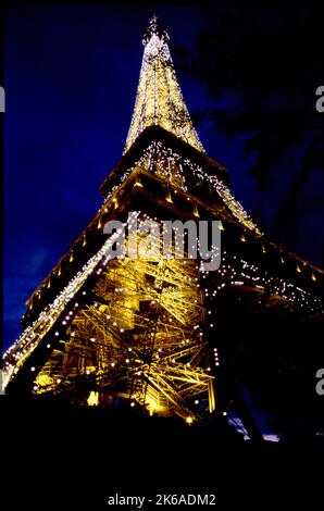 Des lumières étincelantes clignotent depuis la Tour Eiffel à Paris au crépuscule. Banque D'Images