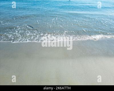 Eau d'ondulation de mer sur sable humide. Plage de sable vide, destination île grecque Cyclades, Grèce. Modèle de vacances d'été, espace, vue de dessus. Banque D'Images