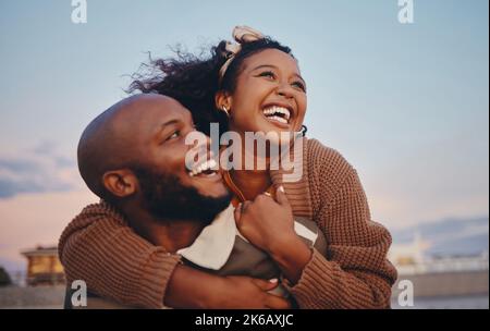 Joyeux couple noir, amour et câlin riant dans le bonheur joyeux pour lier le temps ensemble dans le plein air. Afro-américain homme et femme appréciant Banque D'Images