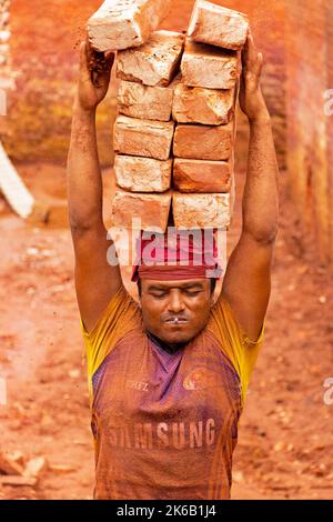 Dhaka, Dhaka, Bangladesh. 13th octobre 2022. Les travailleurs de Dhaka, au Bangladesh, transportent des piles de briques pesant plus de 15 kg sur leur tête alors qu'ils sont disposés avant d'être cuits dans un four. Les ouvriers ''“ qui sont payés moins de Â€1 un quart ''“ déplacent jusqu'à 1 500 briques par jour dans des conditions de sweltering. Vers 4, 00 000 migrants à faible revenu arrivent chaque année à Dhaka en provenance de différentes régions du pays pour travailler à brickfields. De longues heures de travail sous le soleil brûlant dans les champs de briques, une accumulation massive de poussière, le risque de tomber des camions et des piles de briques, et le transport de l excessif Banque D'Images