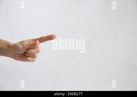 doigt femelle sur fond blanc, pression de doigt, main femelle Banque D'Images