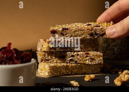 Femme prend le bar énergétique Granola naturel maison. Variété de barres de petit-déjeuner de granola de protéines, avec noix, raisins secs, cerises séchées et chocolat. Nutrition saine alimentation. Collation sans gluten aux céréales Super food Sport Oridge bar Vega dessert concept Banque D'Images