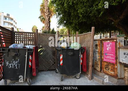 Grandes poubelles en plastique sur roues pleines de sacs en plastique avec différents types de déchets. Banque D'Images