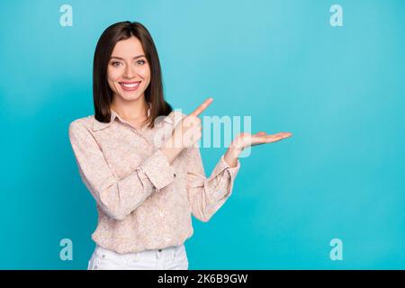 Gros plan photo de la charmante jeune fille paume point de retenue vide espace habillé élégant décontracté look isolé sur fond bleu-vert Banque D'Images