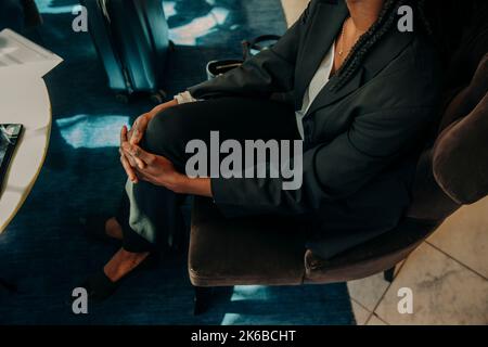 Vue en grand angle de la jeune femme professionnelle assise sur une chaise dans l'hôtel Banque D'Images