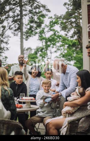 Grand-père donnant un cadeau à petit-fils tout en célébrant l'anniversaire Banque D'Images