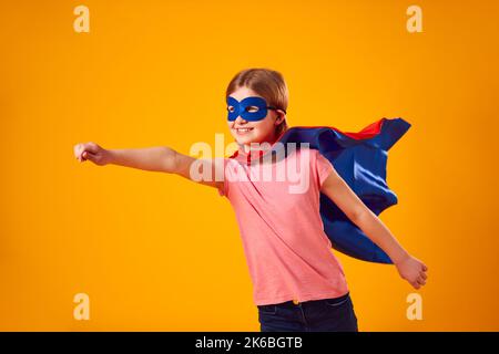 Studio Portrait de fille habillé comme Comic Book Superhero contre fond jaune Banque D'Images