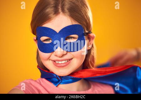 Studio Portrait de fille habillé comme Comic Book Superhero contre fond jaune Banque D'Images