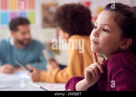 Concentration des étudiantes et étudiants assis au bureau dans la salle de classe de l'école élémentaire Banque D'Images