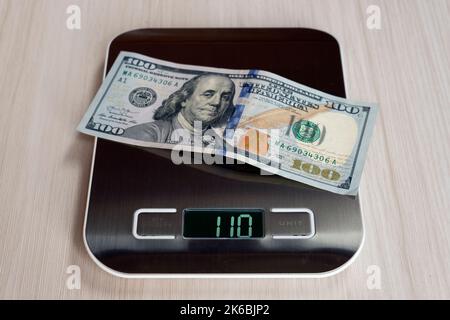 Billets en dollars sur les balances électroniques, un symbole de l'appréciation des coûts, de la déflation, de la surestimation de l'argent. Concept d'inflation aux États-Unis de Banque D'Images